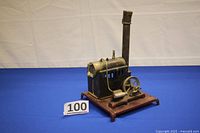 Full view of the antique Weeden toy model steam engine with chimney and mounted on a red base.