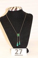 Full view of the necklace displayed on a black mannequin bust, showing the chain length and two drop pendants.