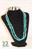 Full view of double strand turquoise necklace displayed on black stand with lot number card.