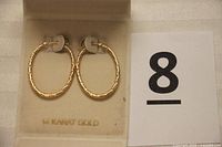 Large 14 karat gold twisted hoop earrings in original box marked 14 KARAT GOLD.