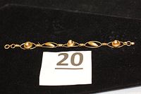Full bracelet laid flat on black background with lot number card