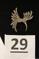 Vintage sterling silver hummingbird pin shown on black background with lot number card