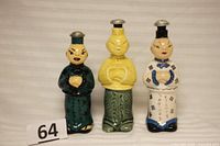Photo showing all three ceramic figurine bottles together, depicting each bottle's colors and metal caps