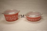 Two pink Pyrex casseroles with white gooseberry pattern, shown with lids and numbered tag 54.