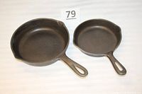 Two cast-iron skillets side by side, showing size difference and pour spouts