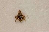 Close-up of the front of the pin showing the gold Masonic emblem with blue enamel G.