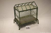 Front view of the terrarium showing its rectangular shape, steel frame with green patina, and clear glass panes.