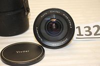 Front view of the Vivitar Auto Wide-Angle 20mm F3.8 lens showing clear lens glass, markings, and original lens cap with Vivitar branding.
