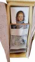 Doll in original packaging with protective inserts inside cream box.