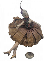 Front view of the porcelain half doll pin cushion showing figure seated with outstretched arms, plaid ribbon details, and fabric skirt.