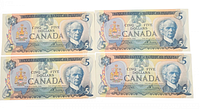 Four Canadian five dollar bills from 1979 showing front side with portrait of Sir Wilfrid Laurier and denomination
