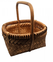 Front angled view of hand woven wooden basket with handle showing weave pattern and construction