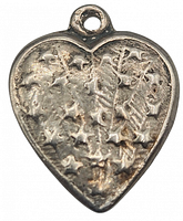 Front view of the miniature sterling silver puffy heart charm showing the embossed star pattern and textured surface.