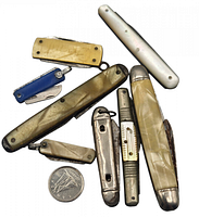Top-down image of all 8 folding pocket cutting tools arranged around a Canadian dime for scale.