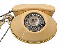 Top view of beige rotary dial phone showing dial, handset cradle, and discoloration.