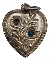 Close-up of front of silver heart charm showing one turquoise stone and detailed floral pattern with one stone missing