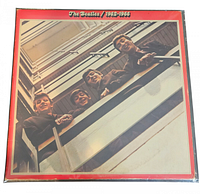 Front cover of The Beatles 1962-1966 vinyl album showing young Beatles members on balcony looking down.