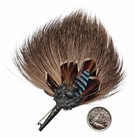 Full view of feather hat pin alongside a Canadian quarter for size reference showing the overall appearance and length of approximately 3 1/4 inches.