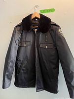 Front view of the black Blauer jacket with fur collar and chest pockets.