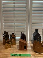 Photo showing all decorative houses in the lot arranged in a row with a window background