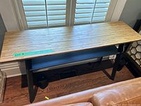 Top angle photo showing bamboo wood grain surface and black metal base with lower shelf