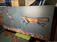 Full view of the stretched canvas showing fox and hare on teal background with floral bottom border