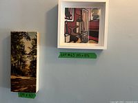 Overall view of two framed artworks on wall, with size labels visible beneath each frame