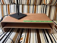 Photo of wooden rectangular desktop shelf with rounded corners and curved edges, labeled with dimensions on green tape.