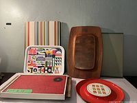 Photo showing multiple serving trays and platters arranged on a surface, including wooden, plastic, and a hot plate