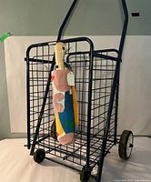Photo showing collapsible metal shopping cart with fabric tote bag attached inside.
