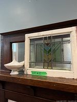 Stained glass panel and Lenox dish on wooden shelf, showing size and framing details.