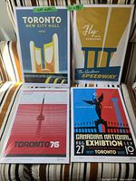 Four posters arranged in two rows showing Toronto landmarks: New City Hall 1965, The Gardiner Speedway, Toronto 76, Canadian National Exhibition 1937.