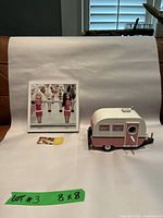 Overview of lot with vintage Barbie and Ken photograph next to pink and white wooden toy trailer and small card