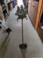 Full image of the brass stand showing the entire height, base, and sailboat top detail.