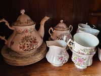 Set of Royal Standard fine bone china tea set pieces including teapot, creamer, sugar bowl, cups and saucers with floral design.