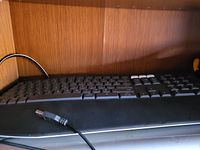 Photo showing the black wired USB keyboard with standard layout including additional function keys and USB connector cable.