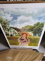Poster with girl holding book and house behind her labeled 'Anne of Green Gables'.