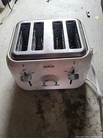 Sunbeam 4-slice stainless steel toaster top view showing four slots, two lever controls, and browning dial.