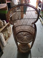 Front view of a small kids size vintage wicker peacock chair with natural brown color and intricate woven pattern.
