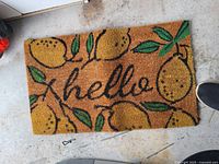 Photo of the front side of the welcome mat showing lemon graphics and 'hello' text