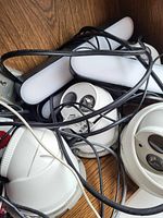 White security cameras and wiring arranged close together on wooden floor, showing dome and bullet camera styles.