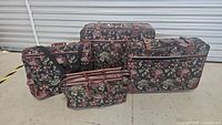 Four-piece floral pattern luggage set arranged on the ground showing different sizes of bags.