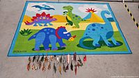 Dinosaur themed children's rug with colorful cartoon dinosaurs and small dinosaur toy figurines arranged neatly in front of the rug