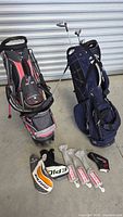 Two golf bags side by side, Maxfli and Sun Mountain, with golf clubs and multiple headcovers spread in front