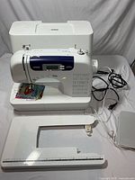 Brother CS-6000i sewing machine with detachable extended sewing table, foot pedal, and power cord on a white background