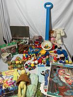 Full lot view showing multiple vintage children's toys including Sesame Street figures, wooden blocks, plush doll, ball popper, and boxed sets.