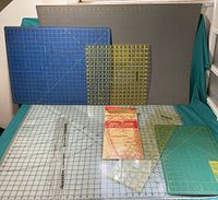 Photo of cutting mats and various quilting rulers on a teal background