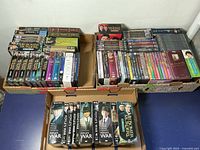 Three boxes containing multiple DVD collections predominantly of British TV series and some movies, arranged in rows showing spines and front covers.