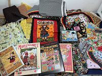 Overview of all fabrics, books, and tin in the lot
