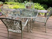 Overview of square patio table and four chairs on wooden deck